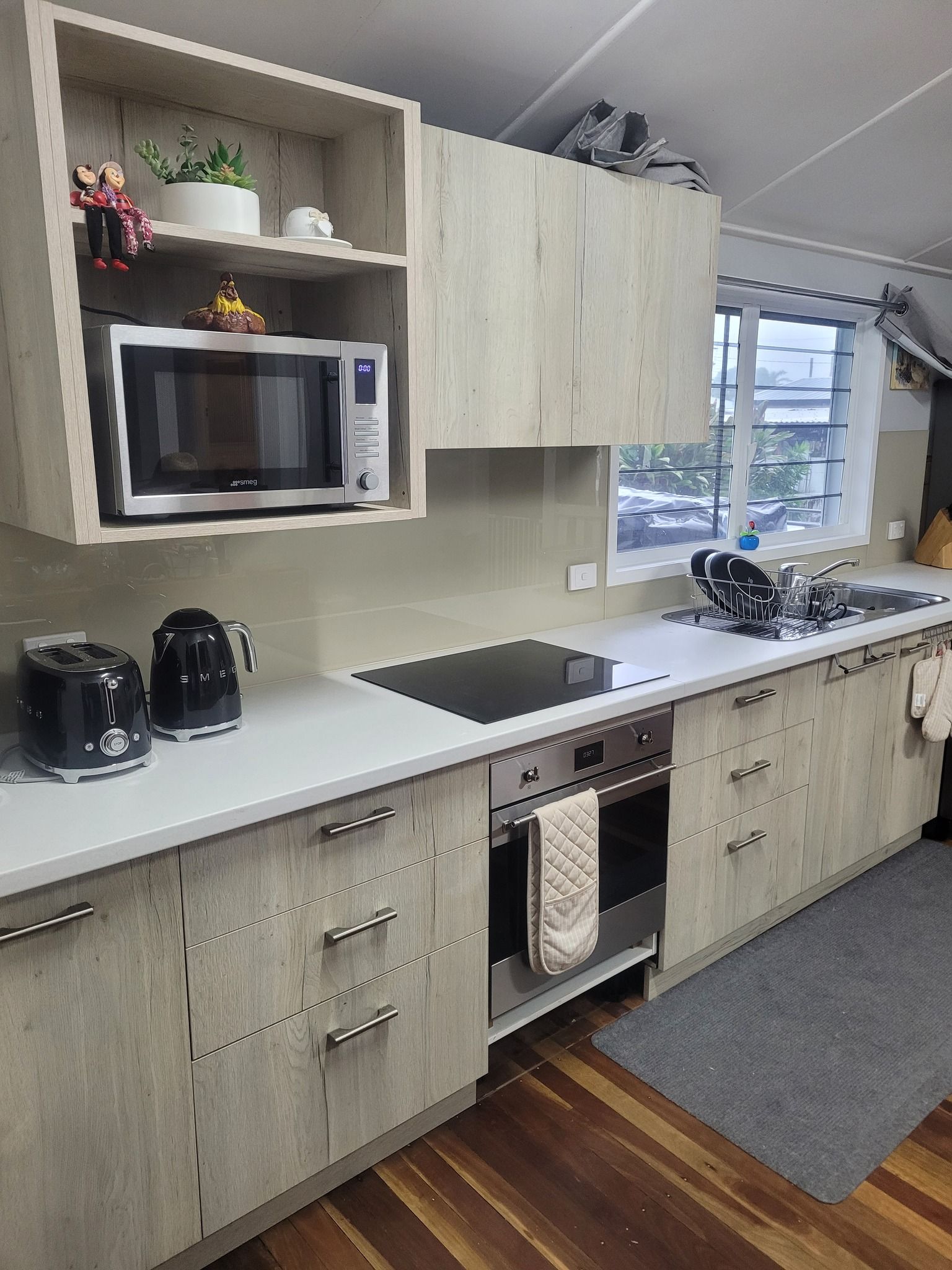 Modern Kitchen With a Gray Granite Island, Stainless Steel Refrigerator — Sams Glass Solutions in Proserpine, QLD
