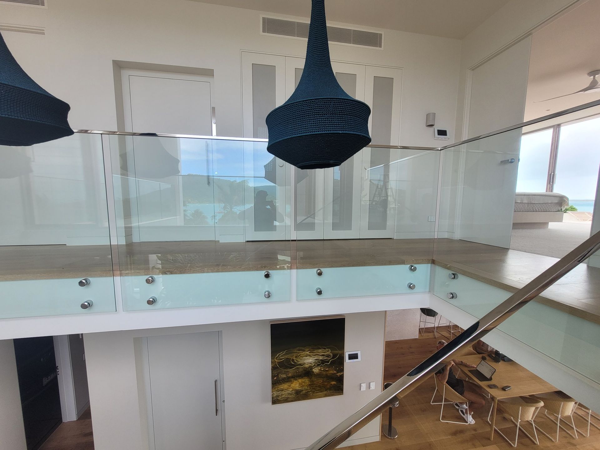 A Wooden Deck With a Dark Railing and Metal Posts — Sams Glass Solutions in Proserpine, QLD