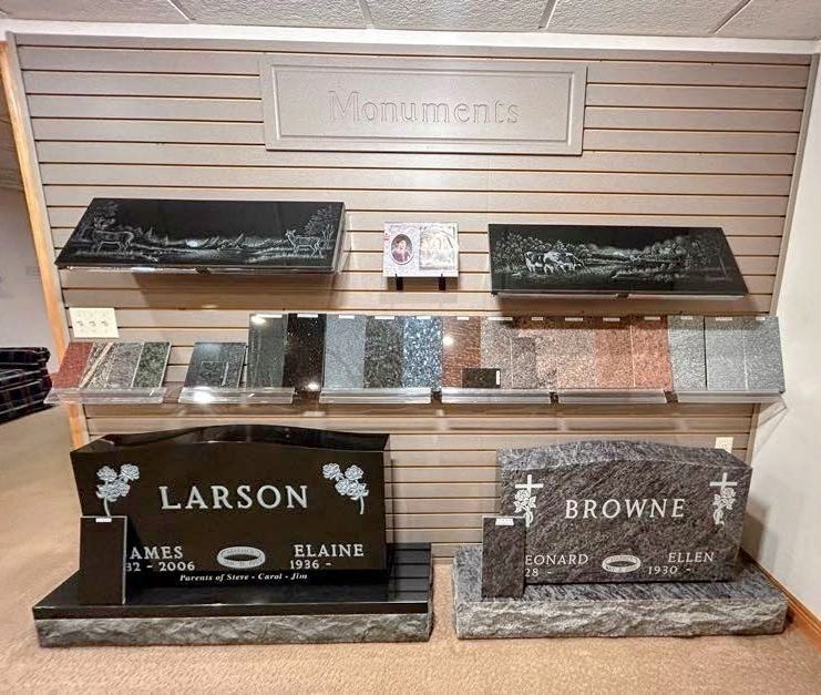 A display of granite grave monuments, featuring two large headstones labeled 