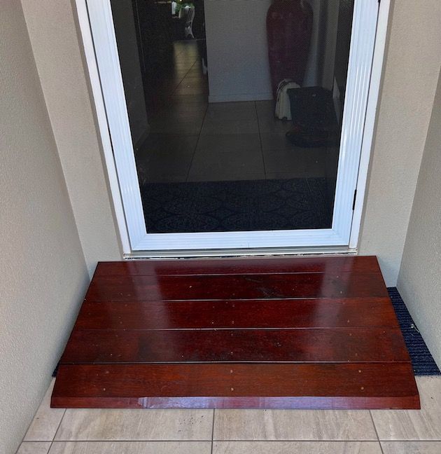 Small wooden step stool in front of a glass door