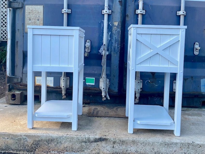 Two light-blue wooden chairs on a concrete ledge against a blue wall with pipes and meters behind them
