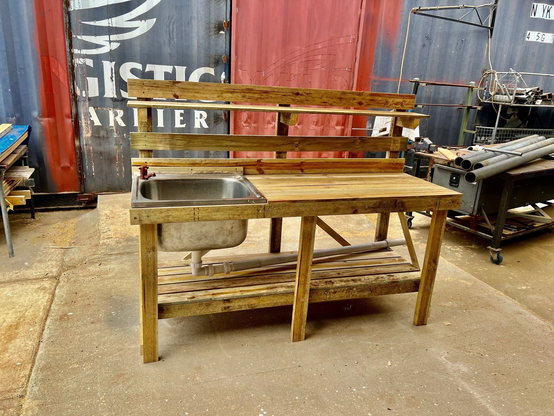Rustic wooden workbench with a metal sink in an industrial workshop