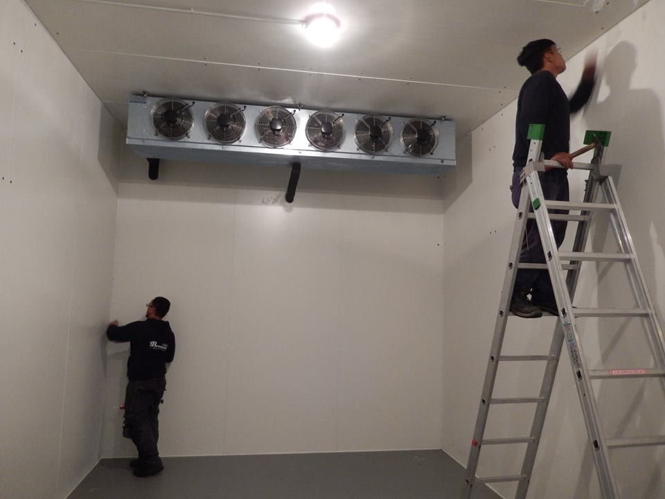 Due persone installano un'unità di refrigerazione