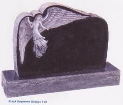 A black granite tombstone featuring a carved angel with spread wings on a rough-hewn stone base.