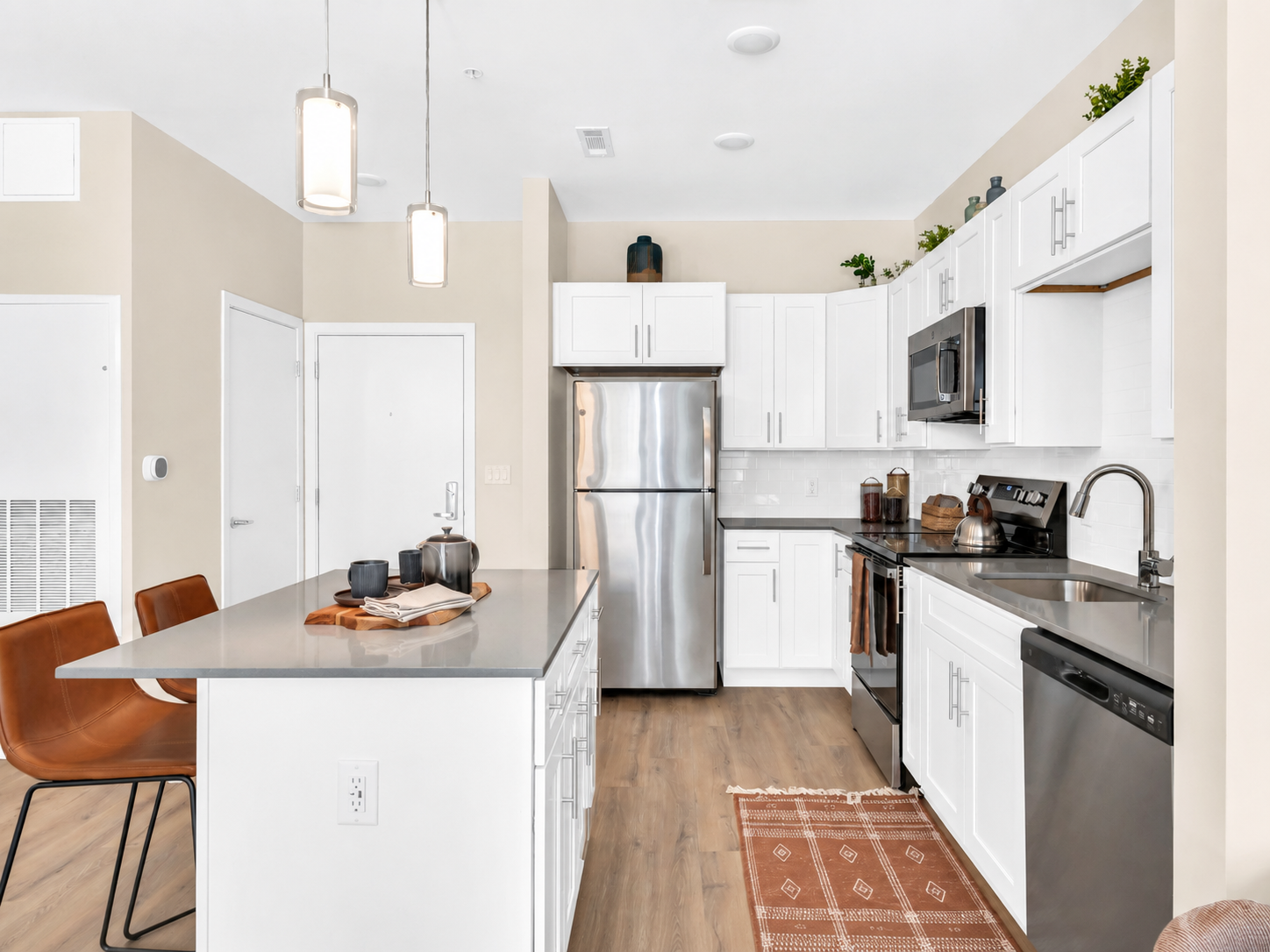 Modern kitchen with white cabinets, stainless appliances, and an island.