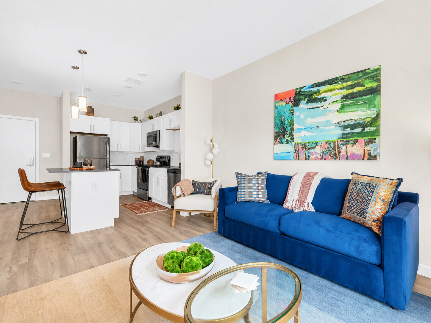 Open-concept floor plan with living room overseeing the apartment kitchen with island.