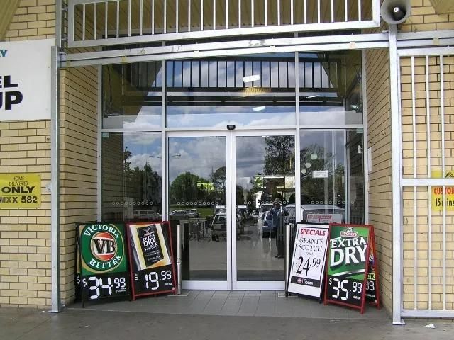 A Store Front With a Sign That Says 'Extra Dry' on It — Patterson Glass Works in Kempsey, NSW