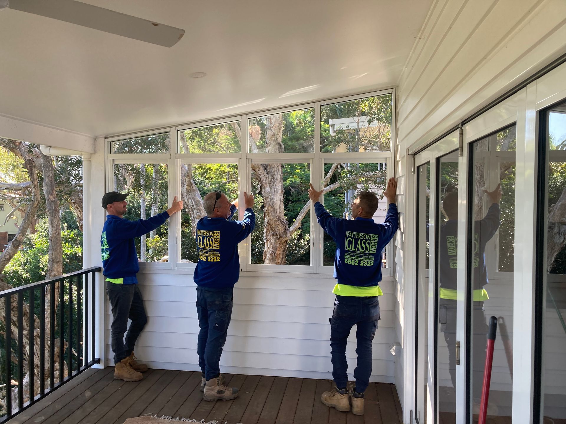 A Group Of Men Are Working On A Porch — Patterson Glass Works in South West Rocks, NSW