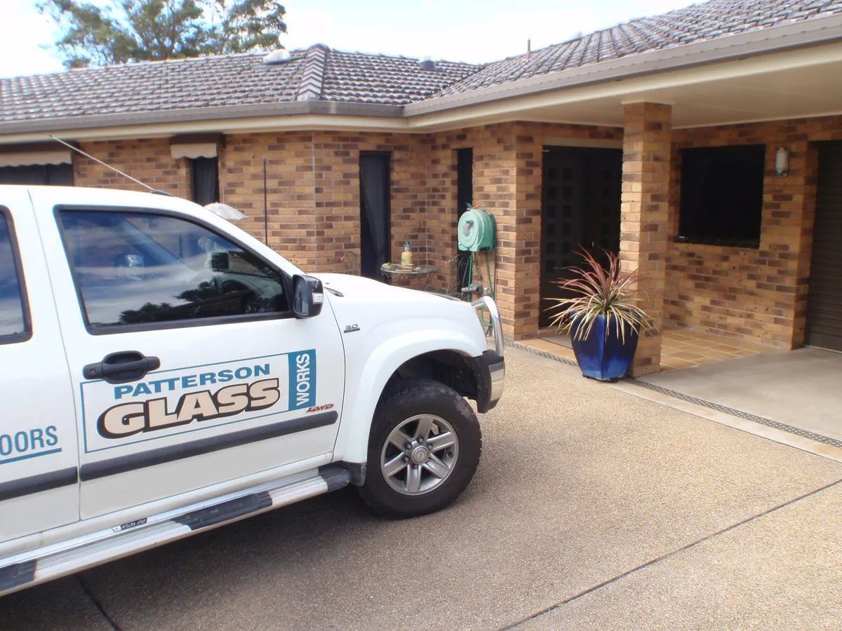 A Brick Wall With a Door That Has Squares on It — Patterson Glass Works in Kempsey, NSW