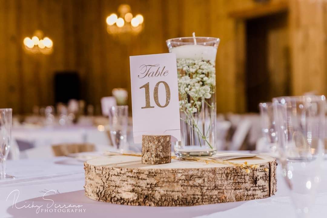 A large room with tables and chairs set up for a wedding reception.