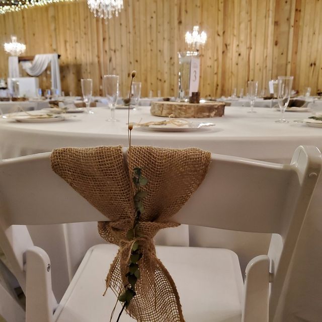 A white chair with a burlap ribbon tied around it