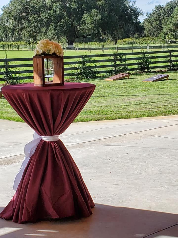 A table with a red tablecloth and a vase of flowers on top of it.