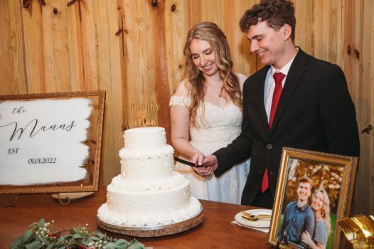 A bride and groom are cutting their wedding cake.