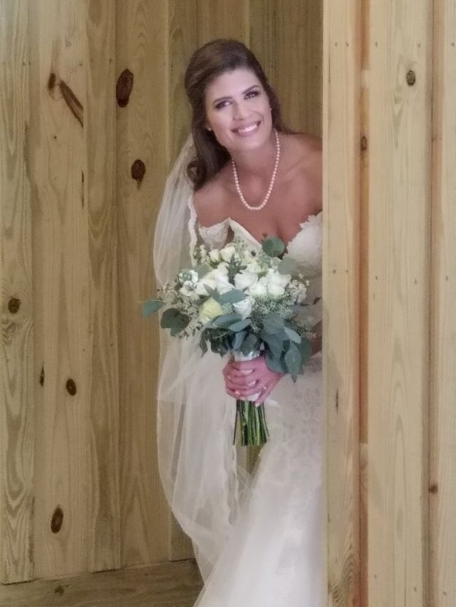 A bride in a wedding dress is holding a bouquet of flowers.