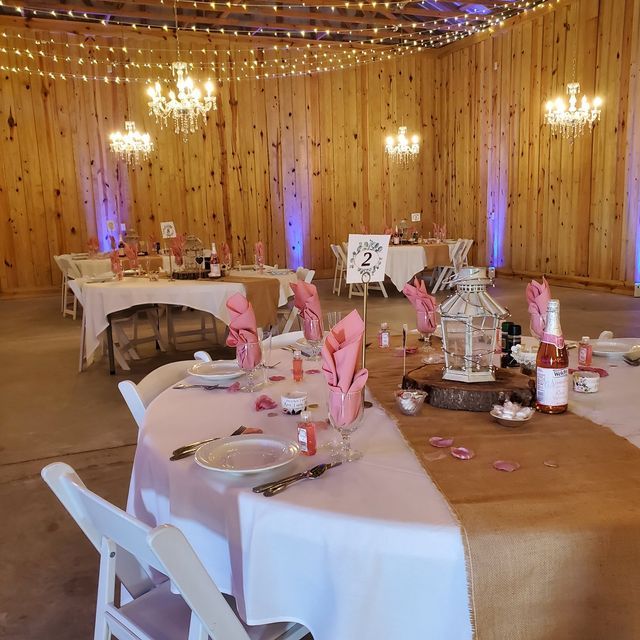 A large room with tables and chairs set up for a wedding reception