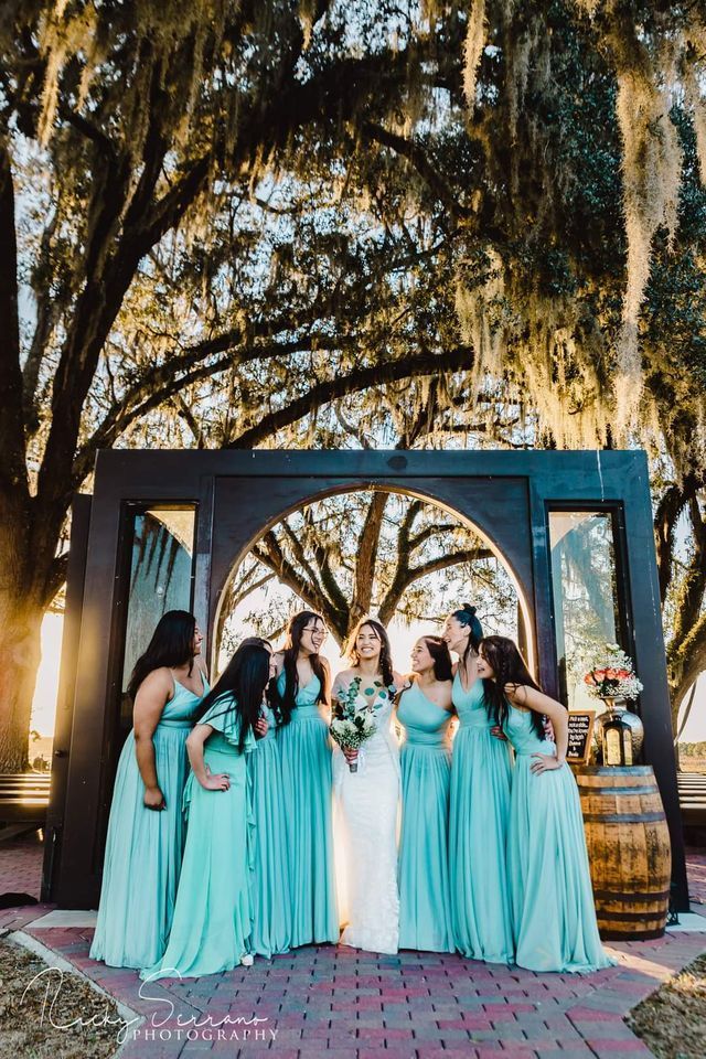 A bride and her bridesmaids are posing for a picture.
