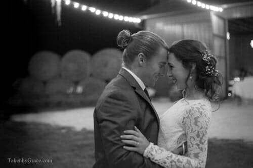 A black and white photo of a bride and groom dancing at their wedding reception.