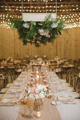 A long table with plates , glasses , and flowers on it.