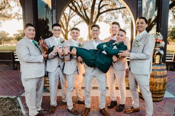 A group of men in suits are holding a woman in their arms.