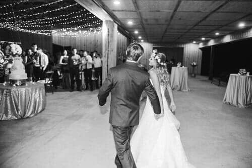A black and white photo of a bride and groom dancing at their wedding reception.