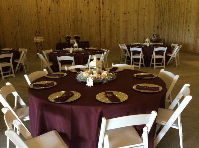 A room with tables and chairs set up for a wedding reception.