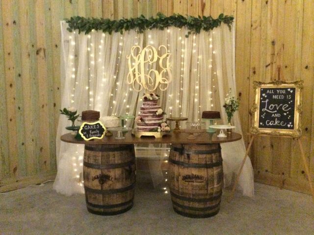 A table with two wooden barrels and a cake on it.