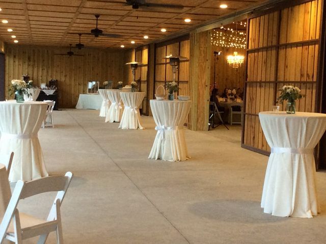 A room with tables and chairs set up for a wedding reception.