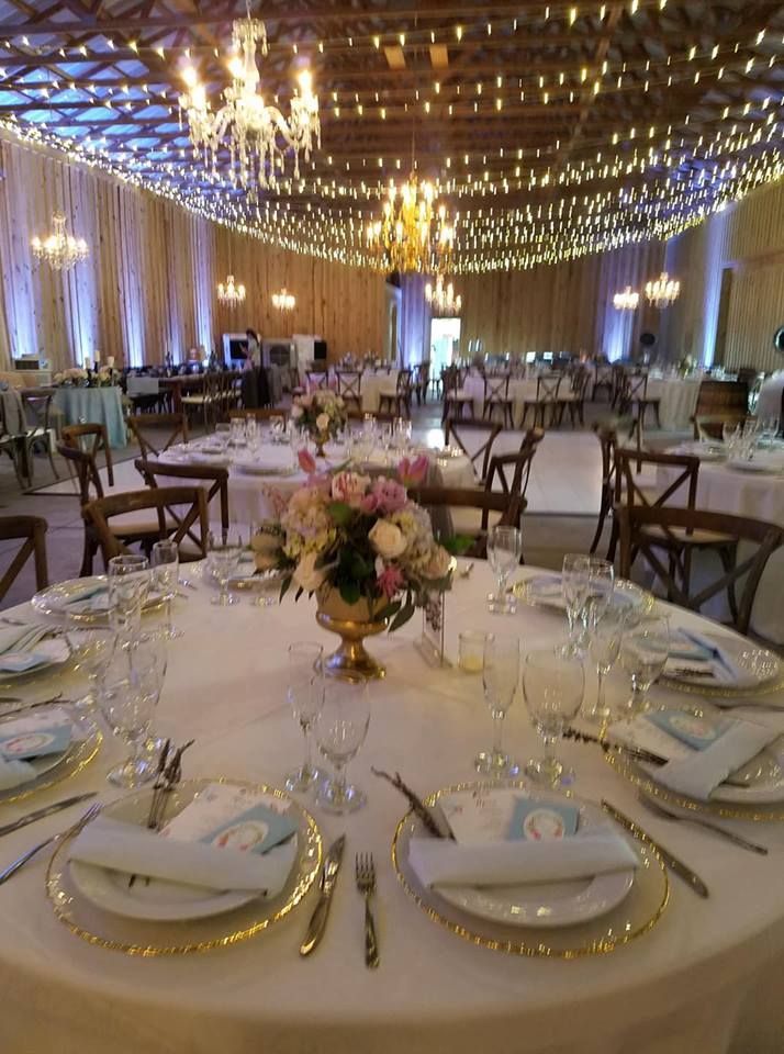 A large room with tables and chairs set up for a wedding reception.