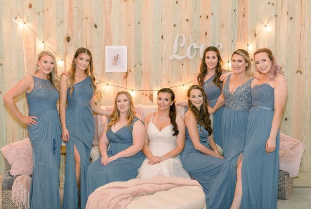 A bride and her bridesmaids are posing for a picture.