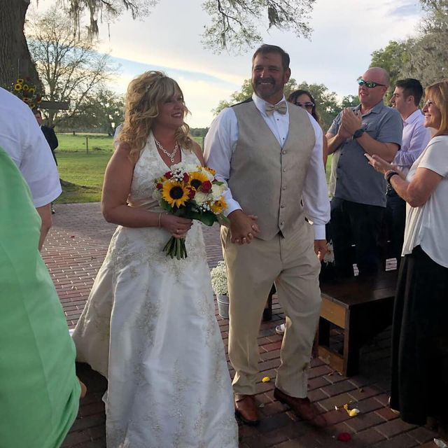 A bride and groom are walking down the aisle at their wedding