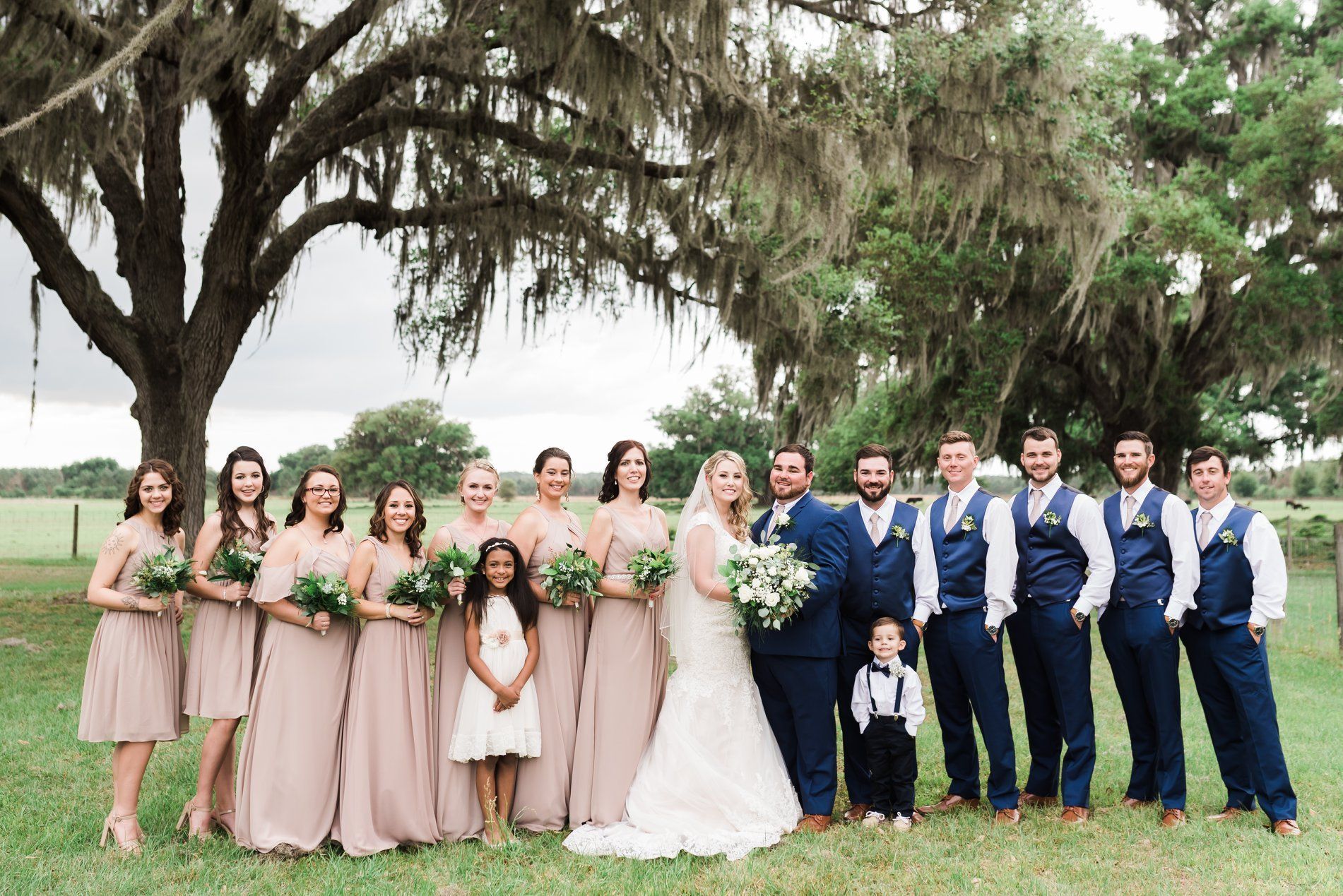 The bride and groom are posing for a picture with their wedding party.