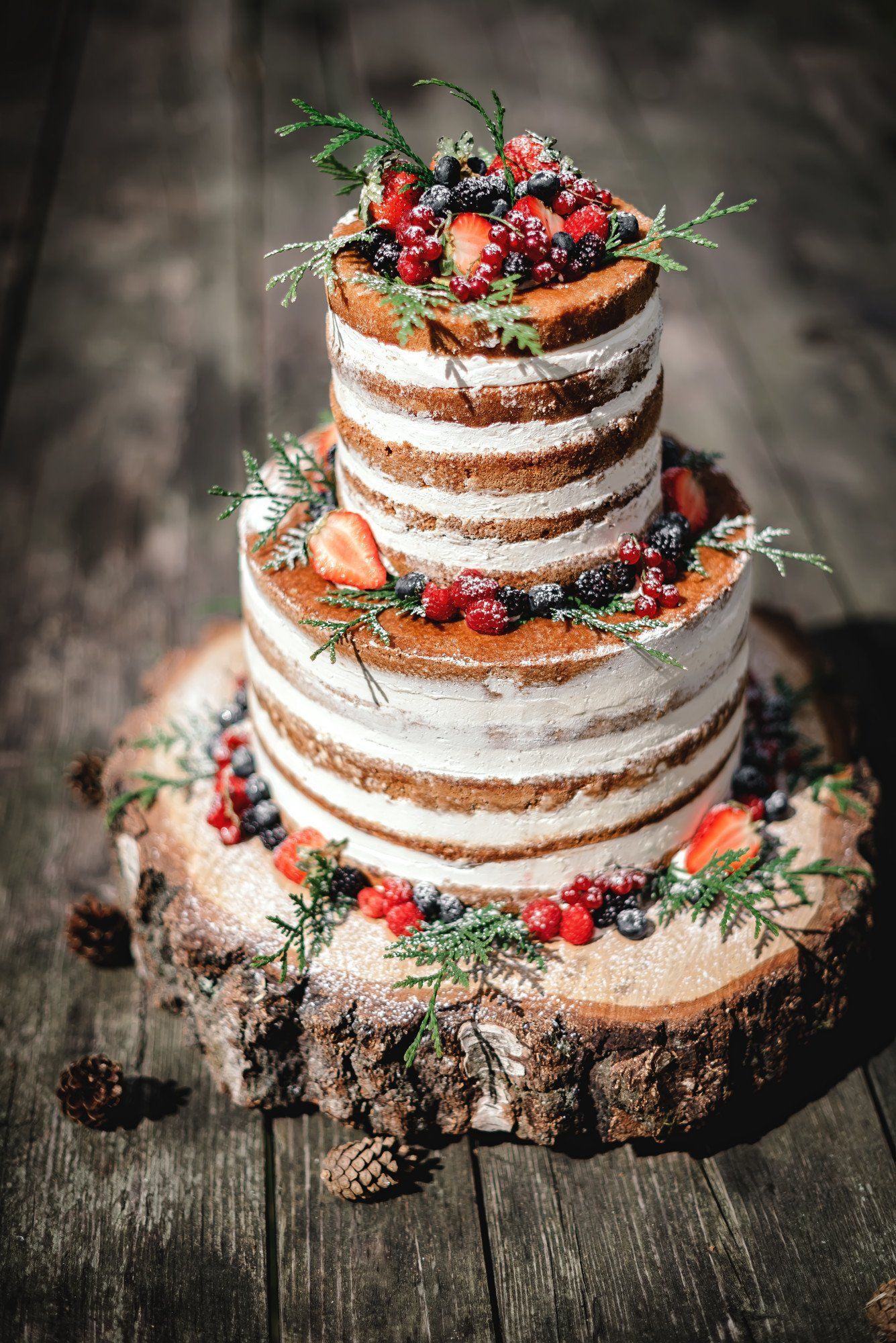 A large rustic wedding cake with strawberries