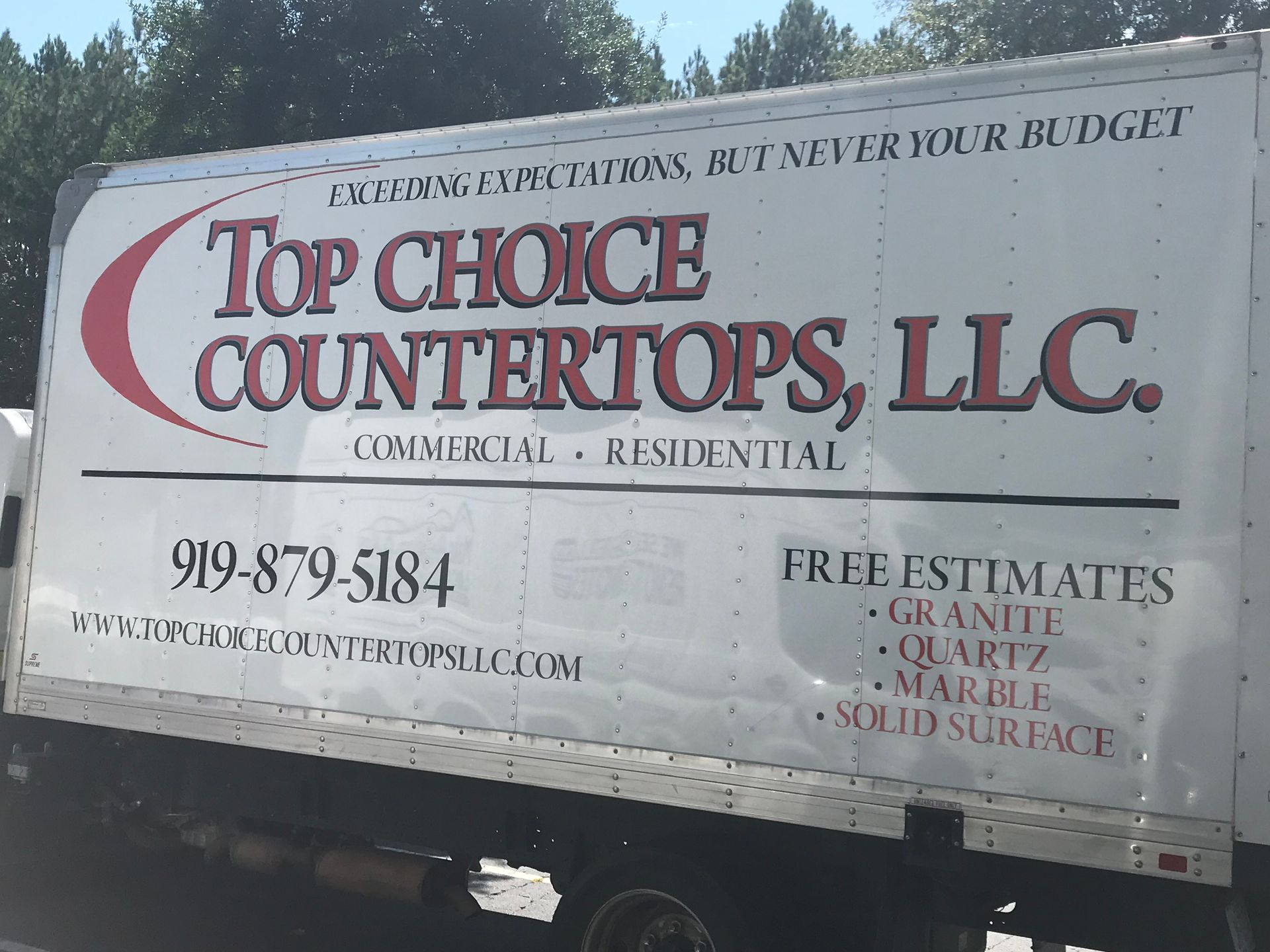 White truck with “Top Choice Countertops, LLC” business sign and contact info on the side.