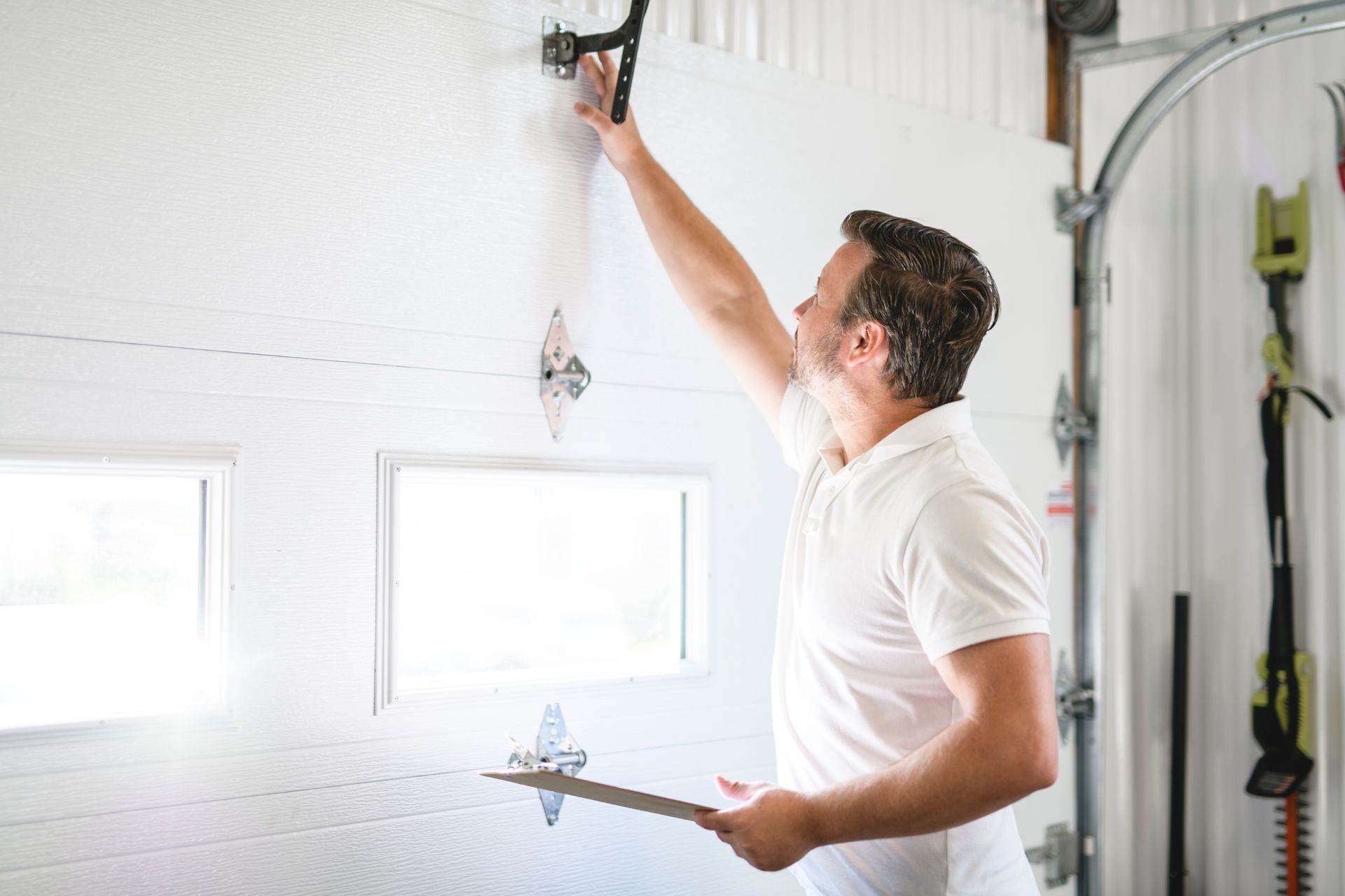 A technician is inspecting a garage door for repair. A technician is inspecting a garage door for repair.