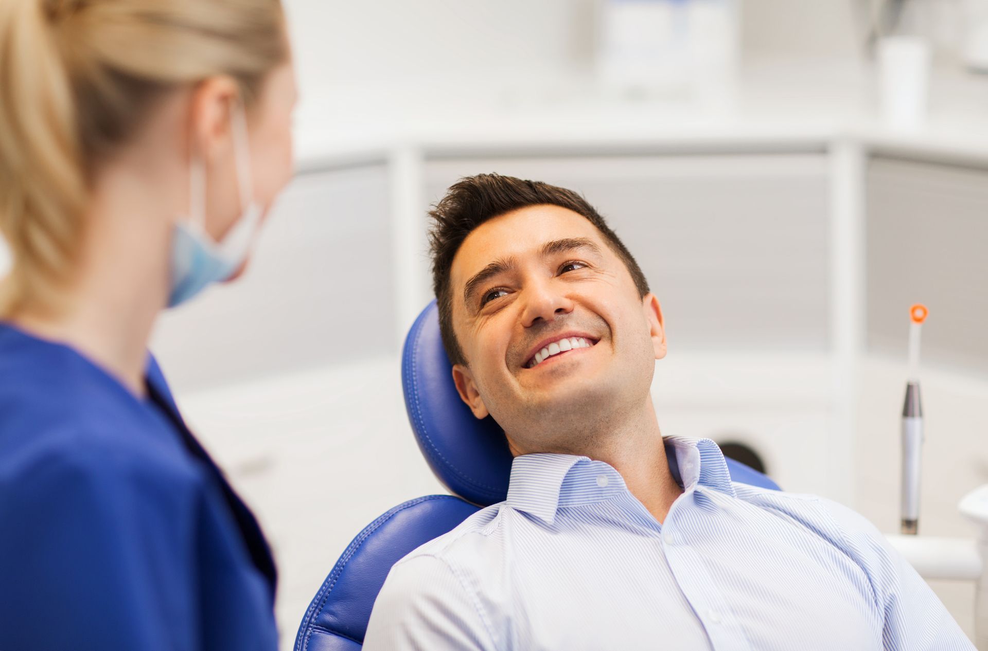 Dentist smiling at a patient in a bright dental office Dentist smiling at a patient in a bright dental office