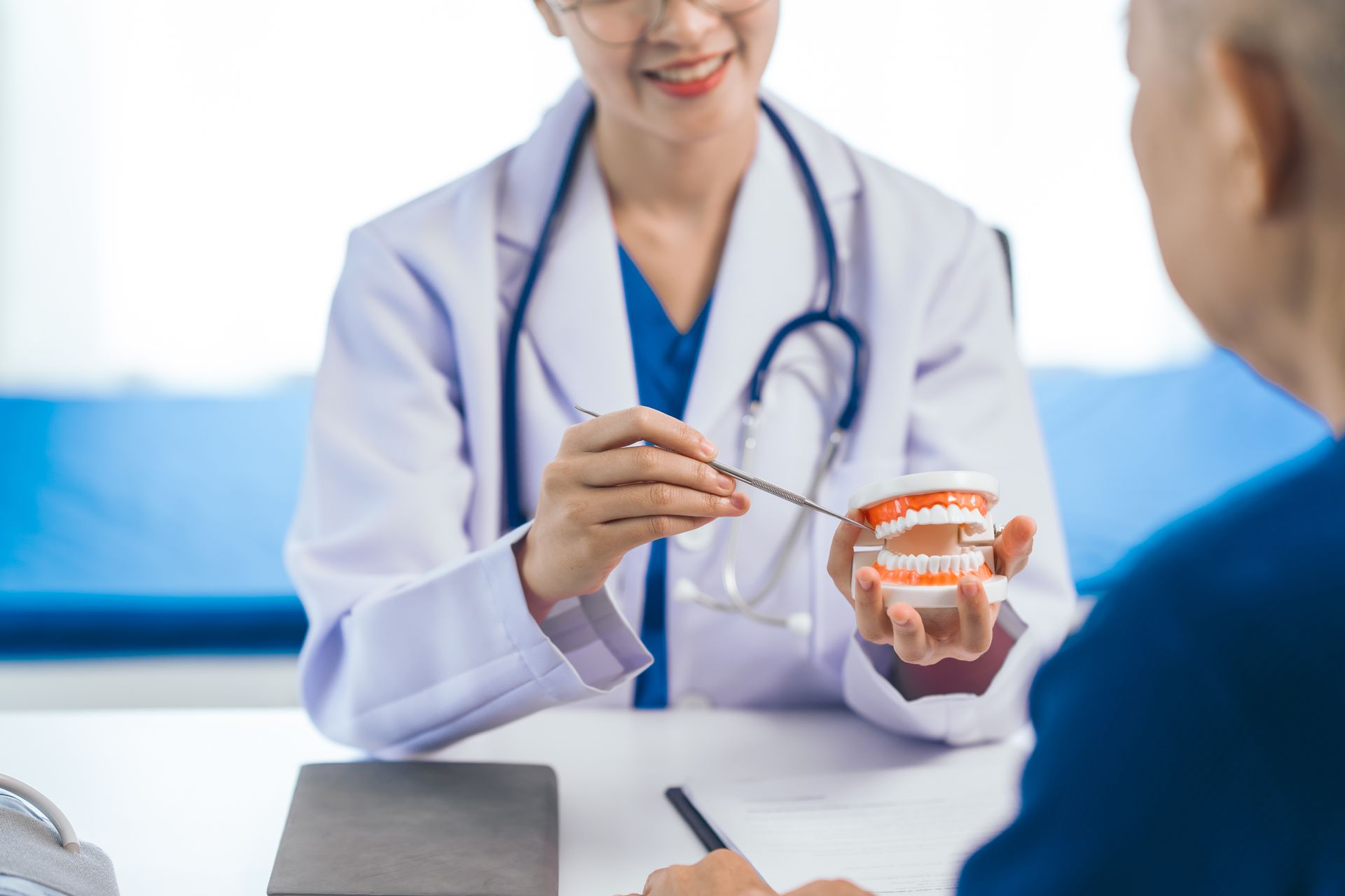 Doctor showing a dental model to a patient during a consultation