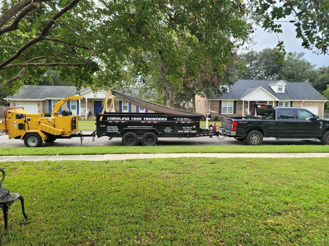 A truck with a trailer attached to it is parked on the side of the road.