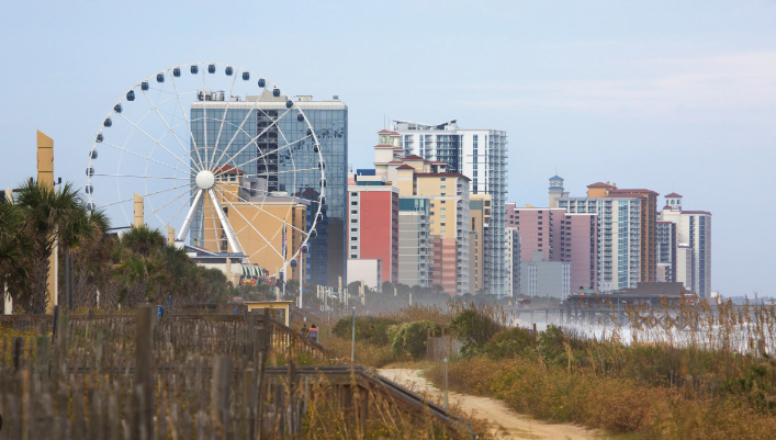 A city skyline with a ferris wheel in the foreground.