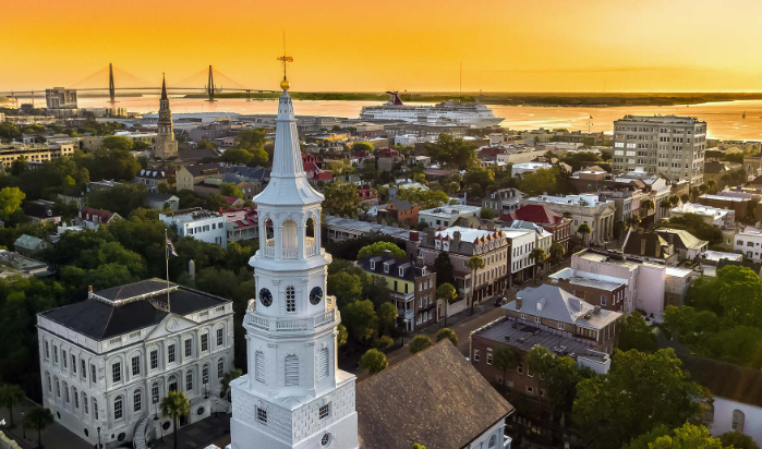 An aerial view of a city with a clock tower in the middle of it.
