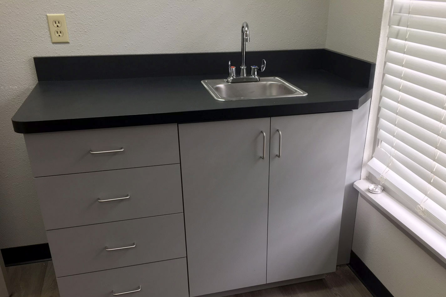 A kitchen counter with a sink and a window