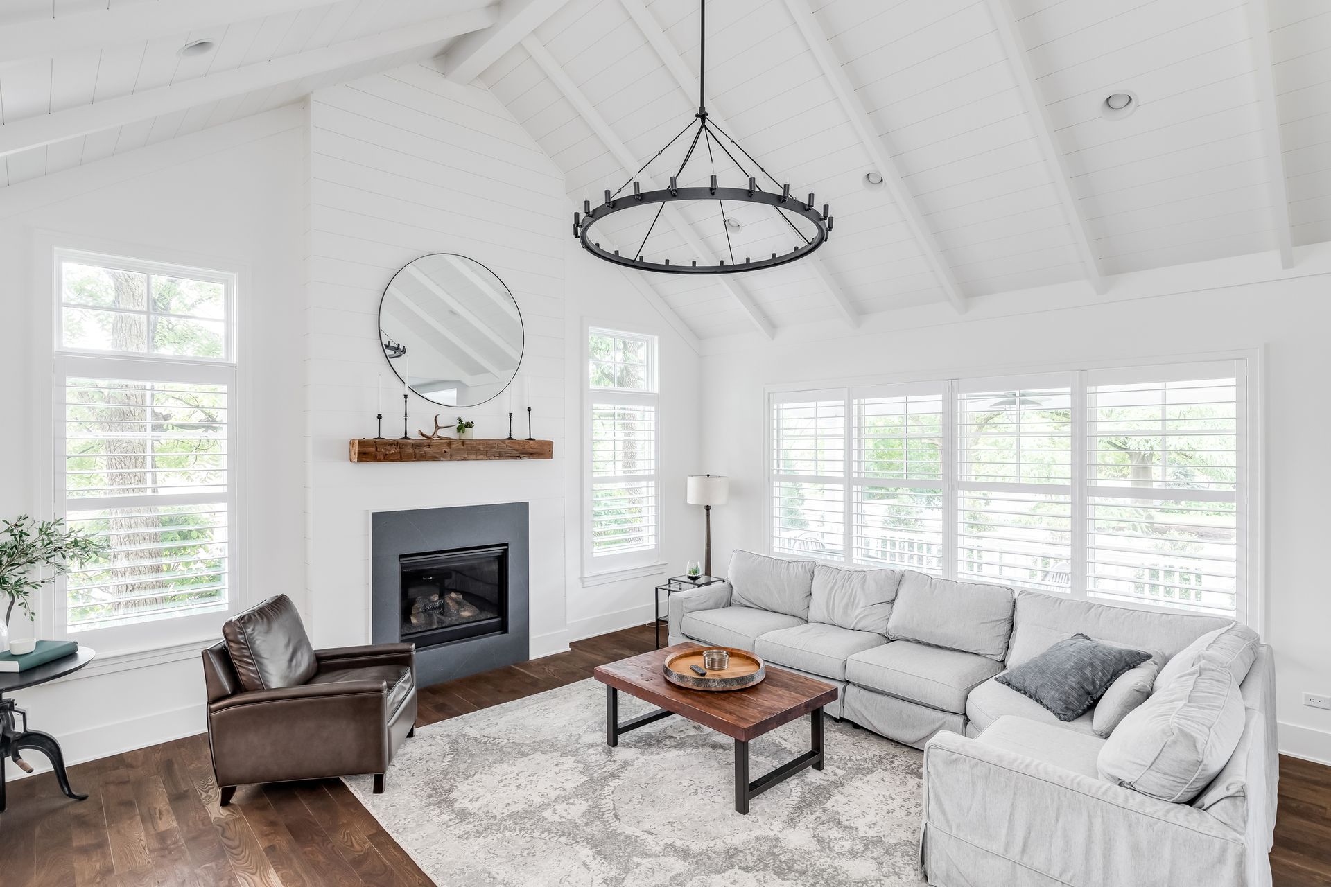 A living room with a couch , chair , coffee table and fireplace.