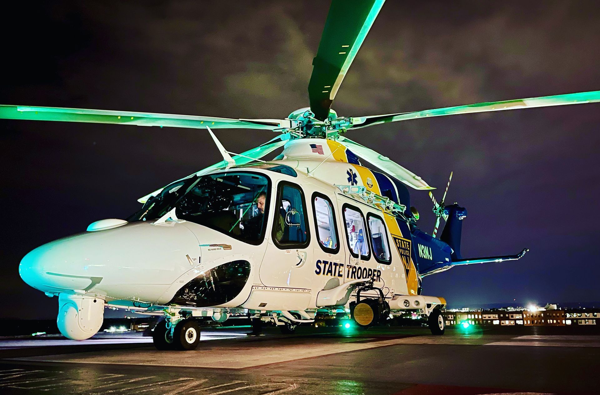 A helicopter is parked on a runway at night