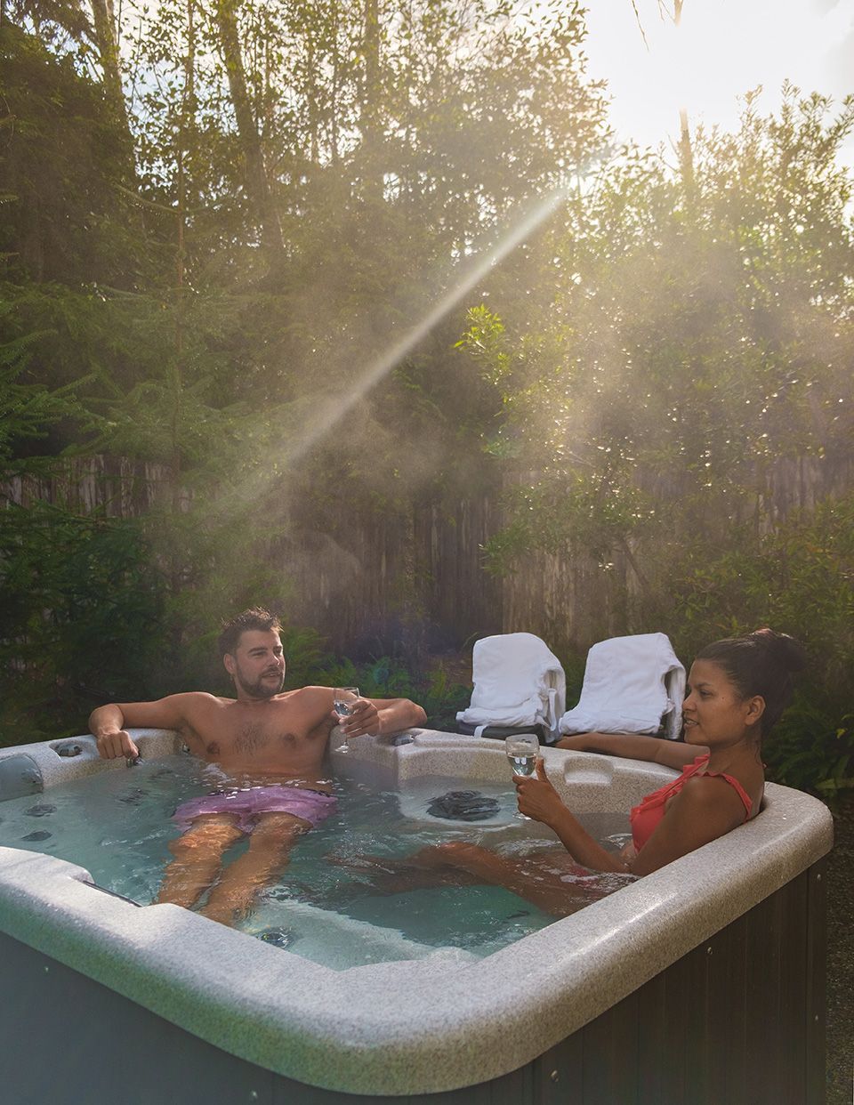 couple in a hot tub bath in the rain forest of Vancouver Island, men and women in a jacuzzi in the garden of rain forest Vancouver Island Canada