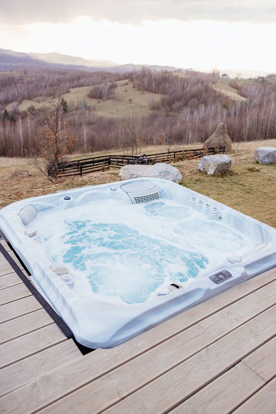 Steaming outdoor hot tub overlooking a serene mountain view 