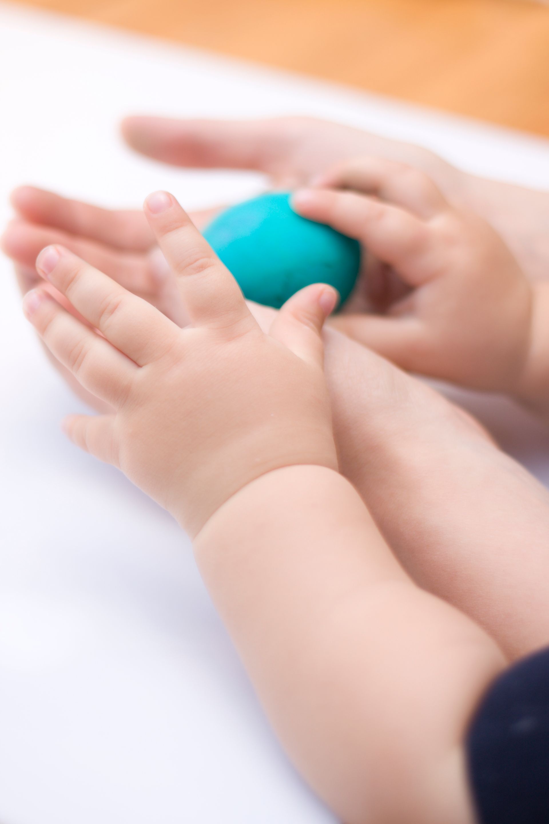 Un bambino e una donna tengono in mano una palla blu.