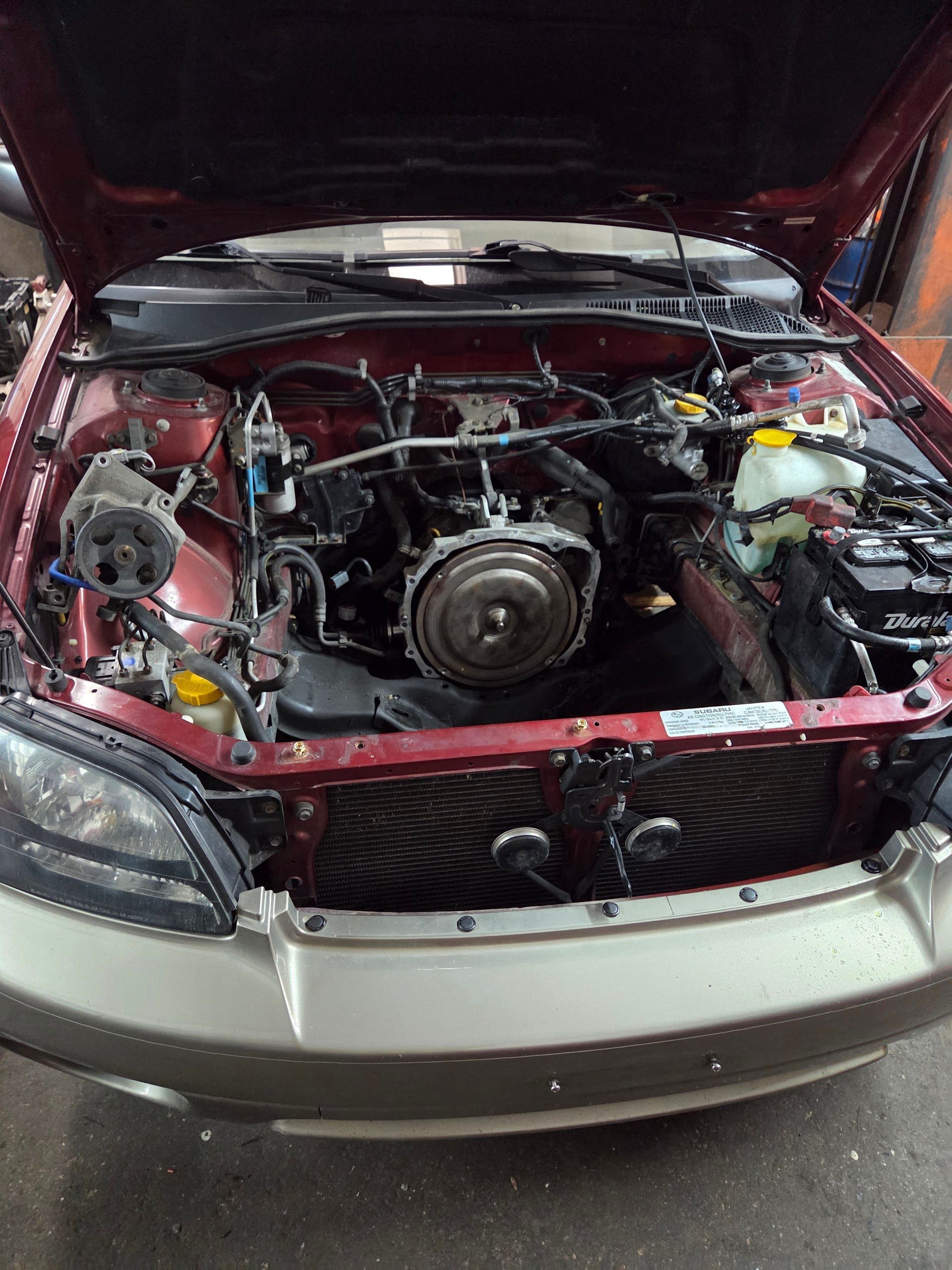 Red Subaru Outback with hood up, engine exposed for repair | Freebird Automotive