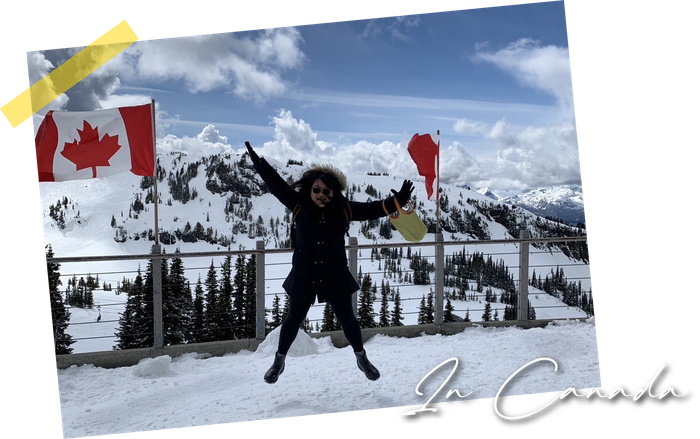 Person jumping in snowy mountains with Canadian flags and a handwritten “In Canada” caption