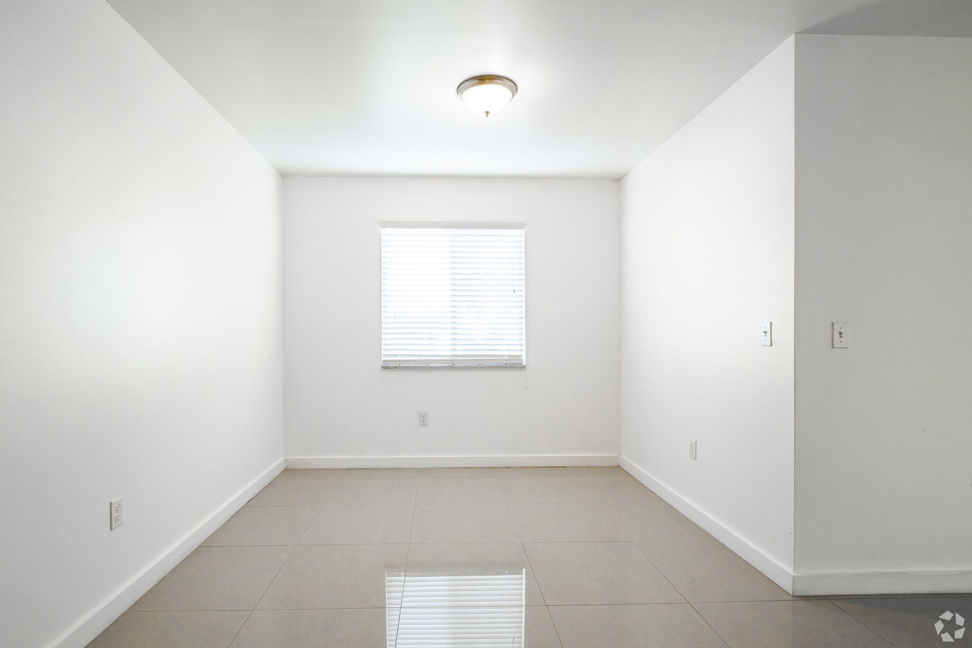An empty room with white walls and a window