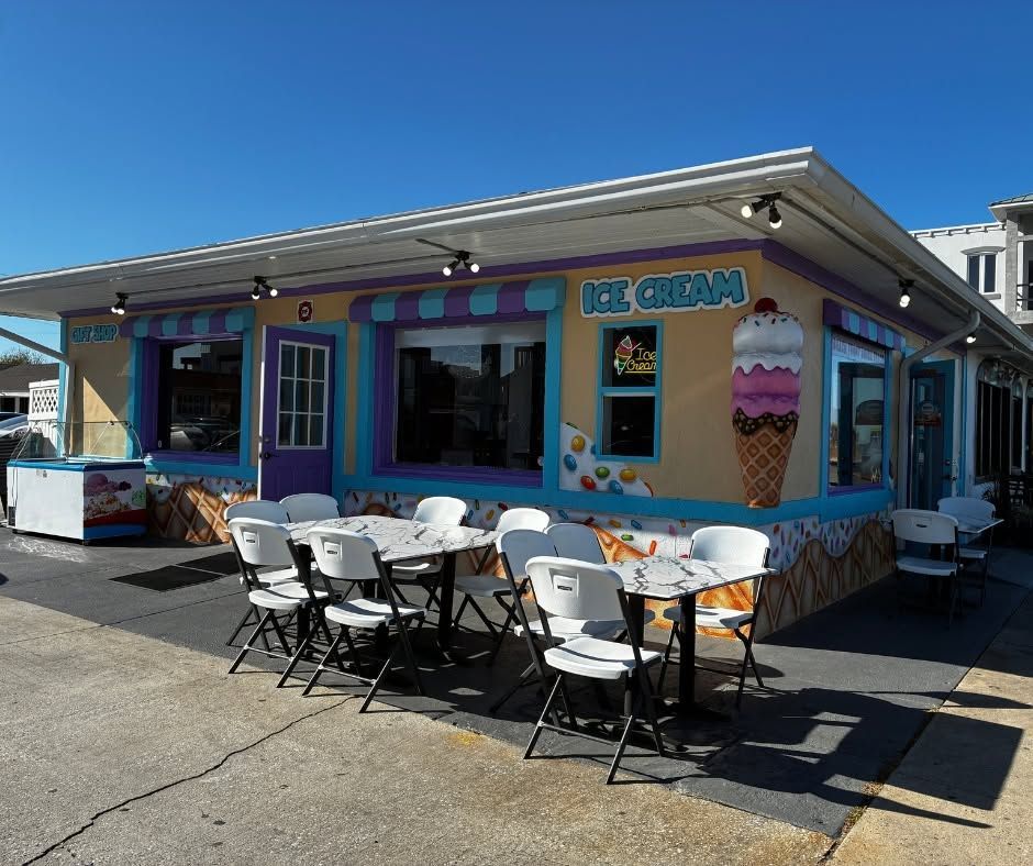 Colorful ice cream shop with outdoor tables and chairs on a sunny day