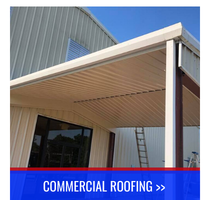 Commercial building with white metal roof awning and ladder under clear blue sky.